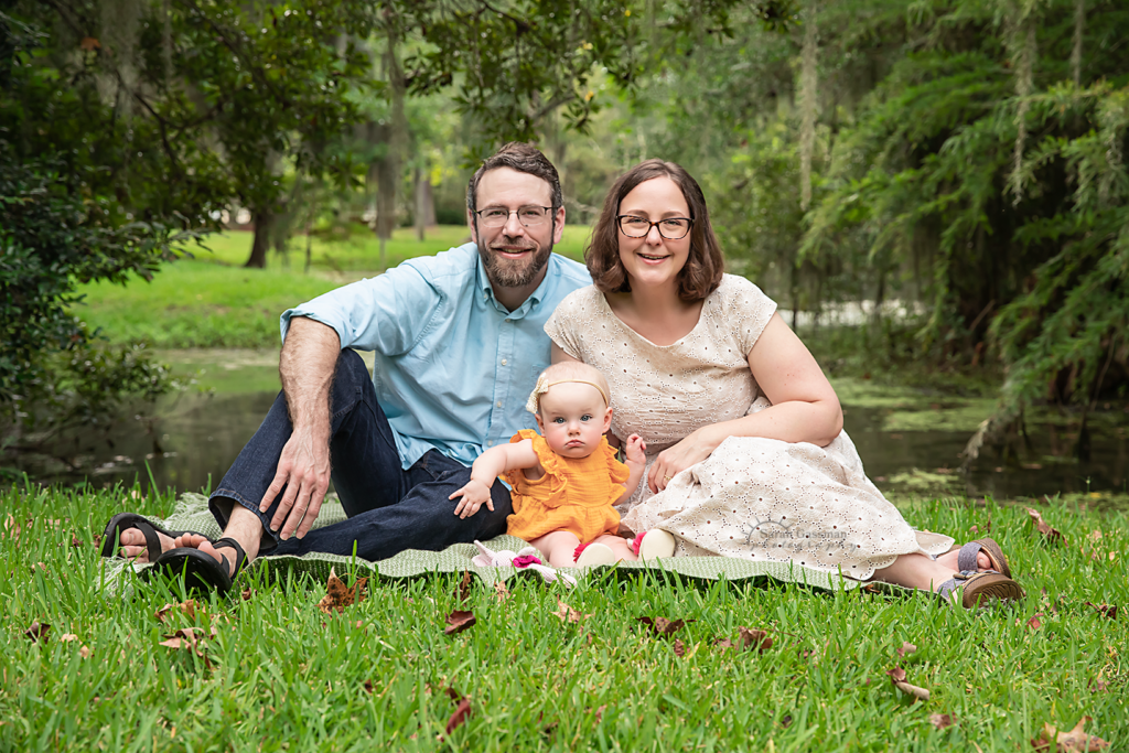 family of three photos with baby in summer grass and green foliage Cypress TX, Cypress family photographer