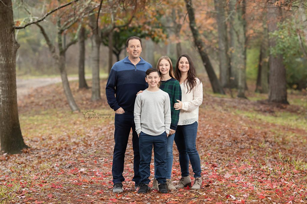 Fall family photos in trees with fallen leaves Cypress TX, Houston family photographer