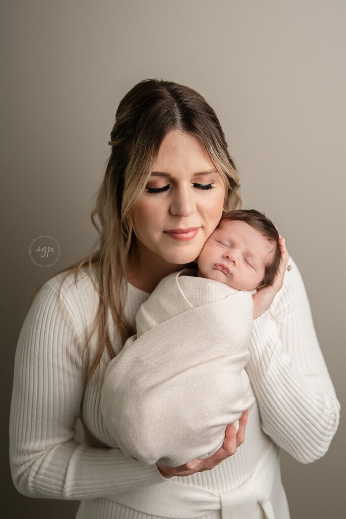 new mom holding baby newborn at in-home Houston newborn photoshoot