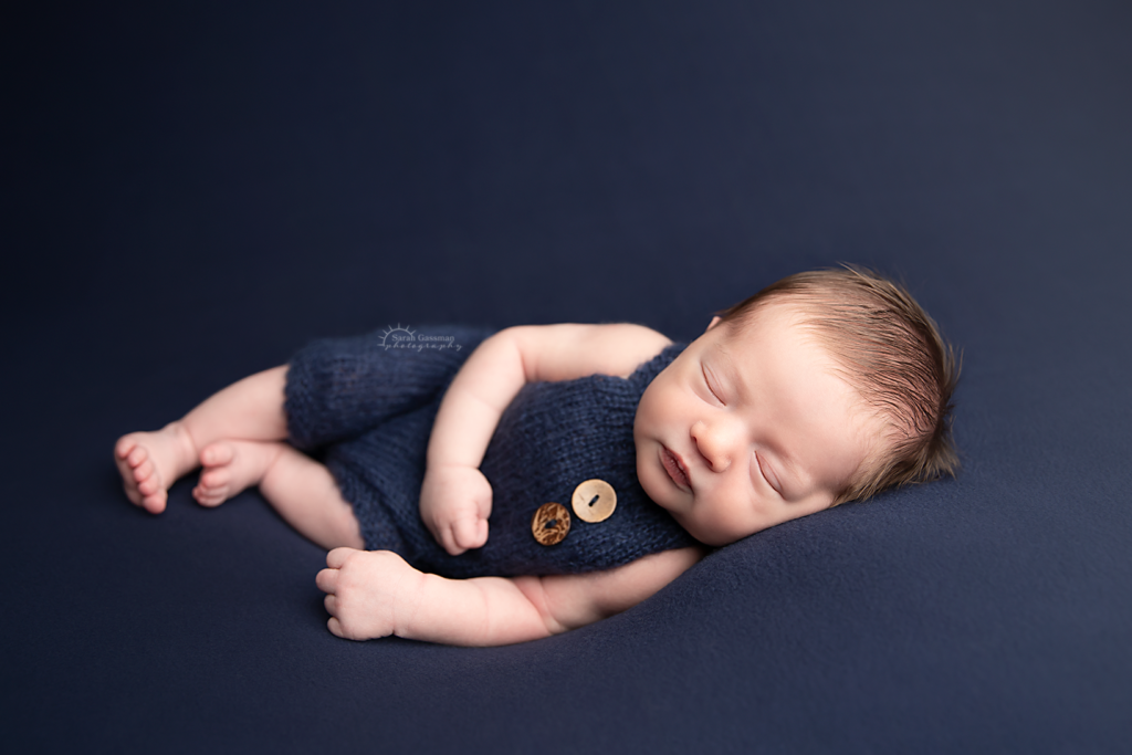 baby boy in navy blue knit romper at in-home newborn session Cypress Texas