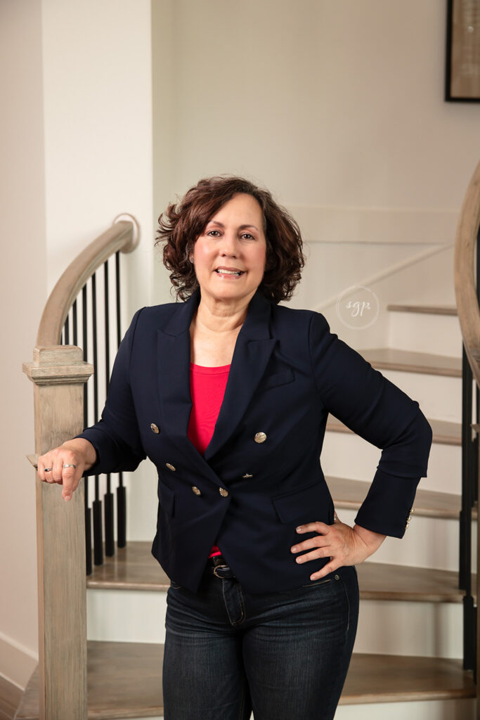 woman realtor posed by stairs at personal branding photo session in Cypress Texas