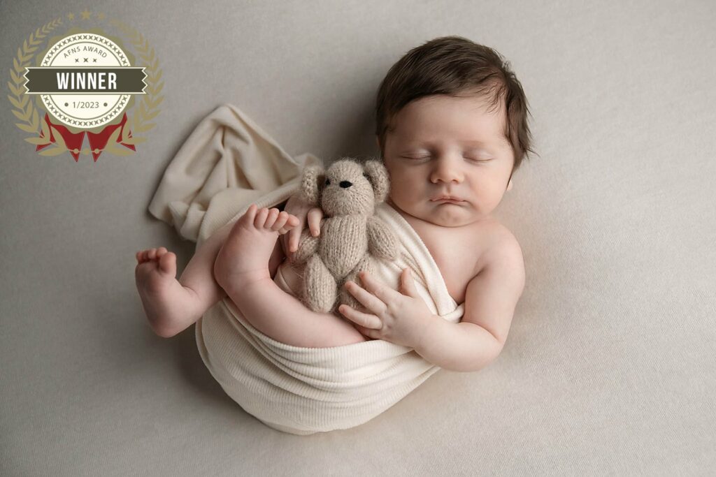award winning image of baby boy in oatmeal color with tiny teddy bear at in-home newborn photo portrait session near Cypress Texas. Houston newborn photo session, Houston newborn portraits