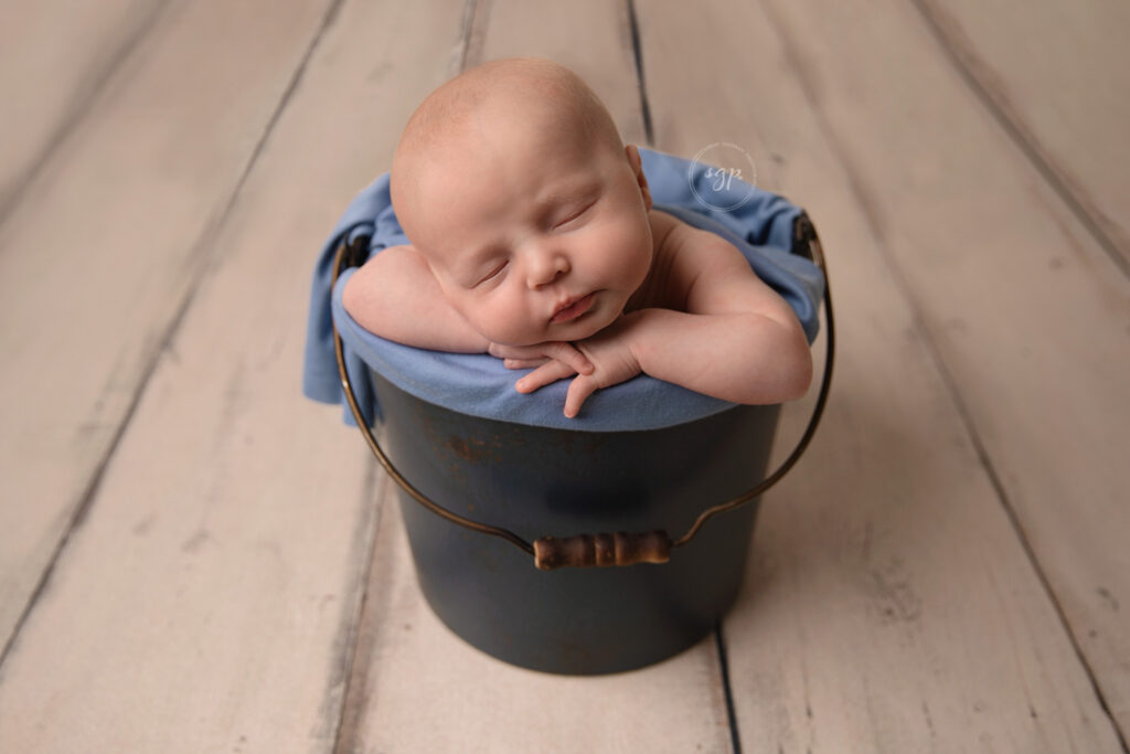 baby boy sleeping in bucket at in-home newborn photo session Hosuton
