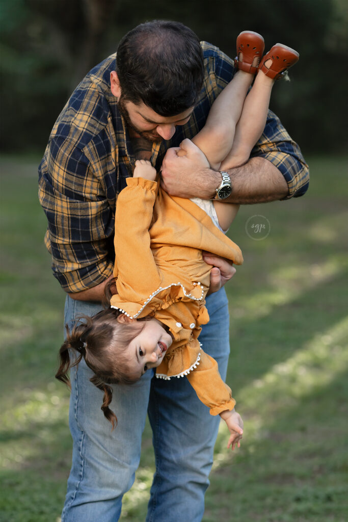 Dad and daughter play at outdoor family photoshoot in Houston, Texas