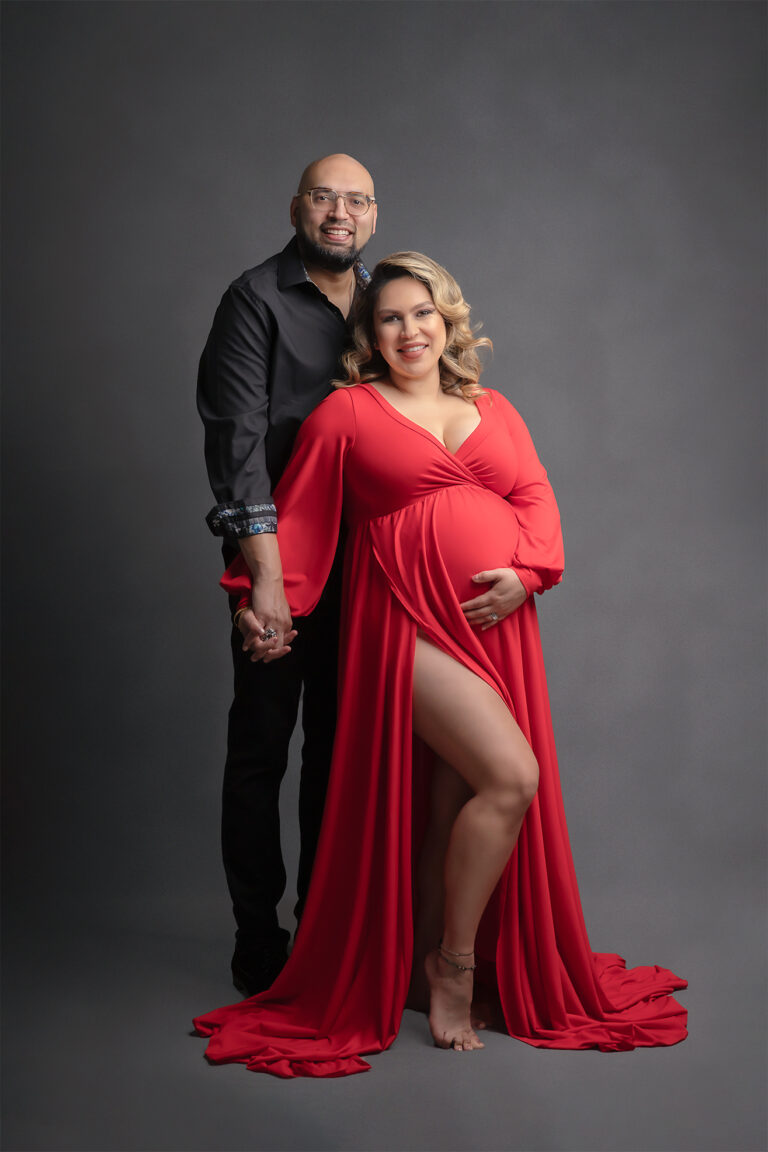 power couple with dad to be in black and mom to be in red dress at Houston maternity photo session