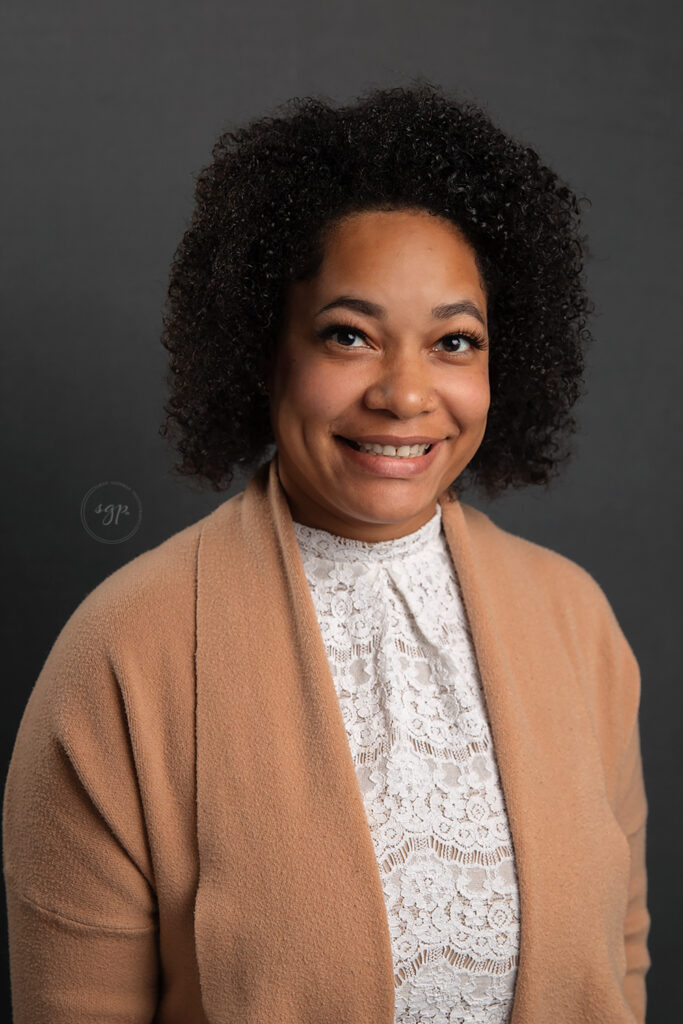 headshot of woman in white lace top with camel colored cardigan