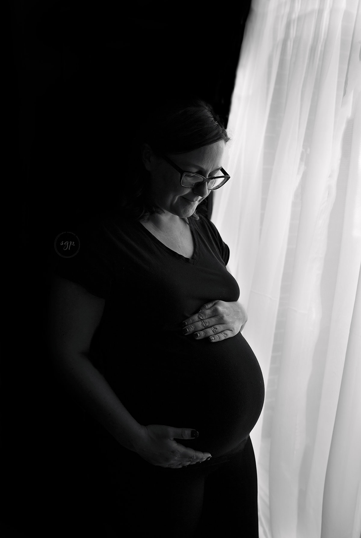 black and white silhouette of mom with baby bump by window, maternity session cypress Texas, cypress tx maternity photographer