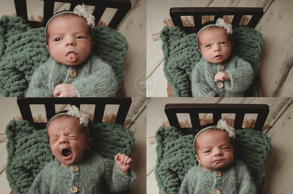 baby girl in a sage knitted sleeper makes lots of faces at her newborn photoshoot while lying on a baby bed