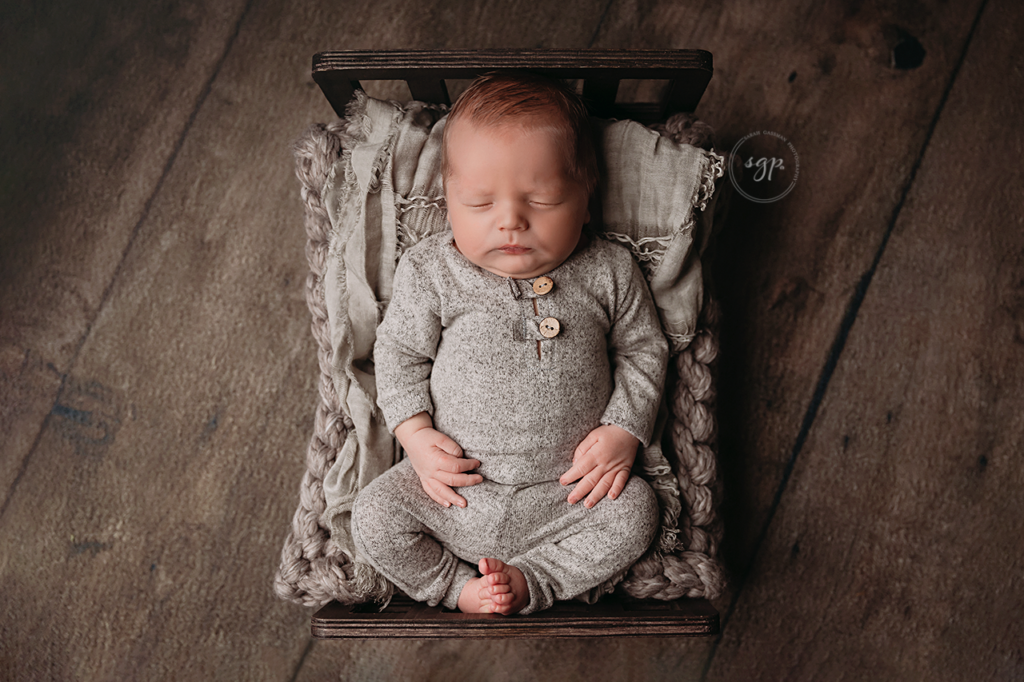 baby sleeping on baby bed prop in gray and brown at at-home newborn photoshoot in Houston, Texas, Katy newborn photographer