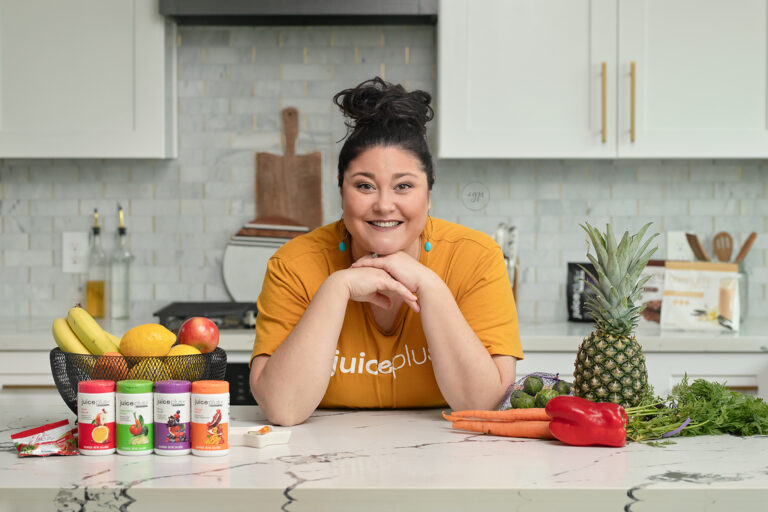 Woman selling Juice Plus+ showcases some products in beautifully designed kitchen